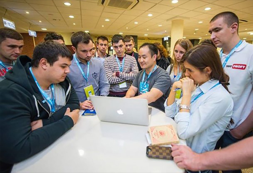 Dennis Yu coaching a group of young marketers around a laptop